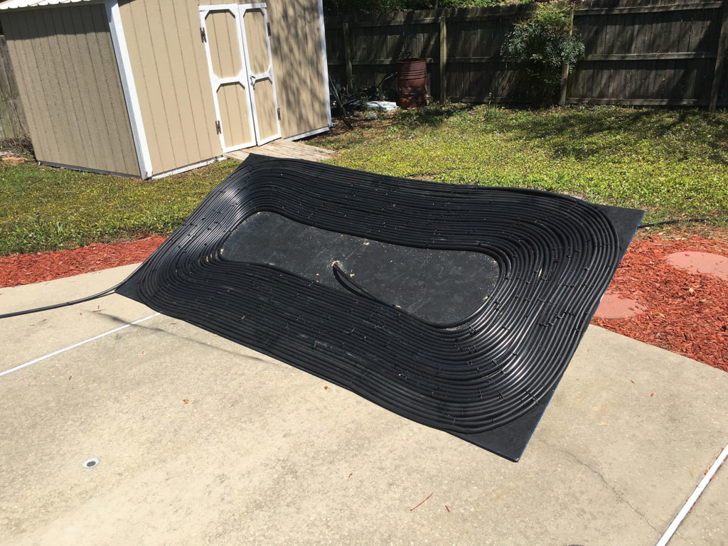 Completed black hose pool heater panel with tight 500-foot coil pattern